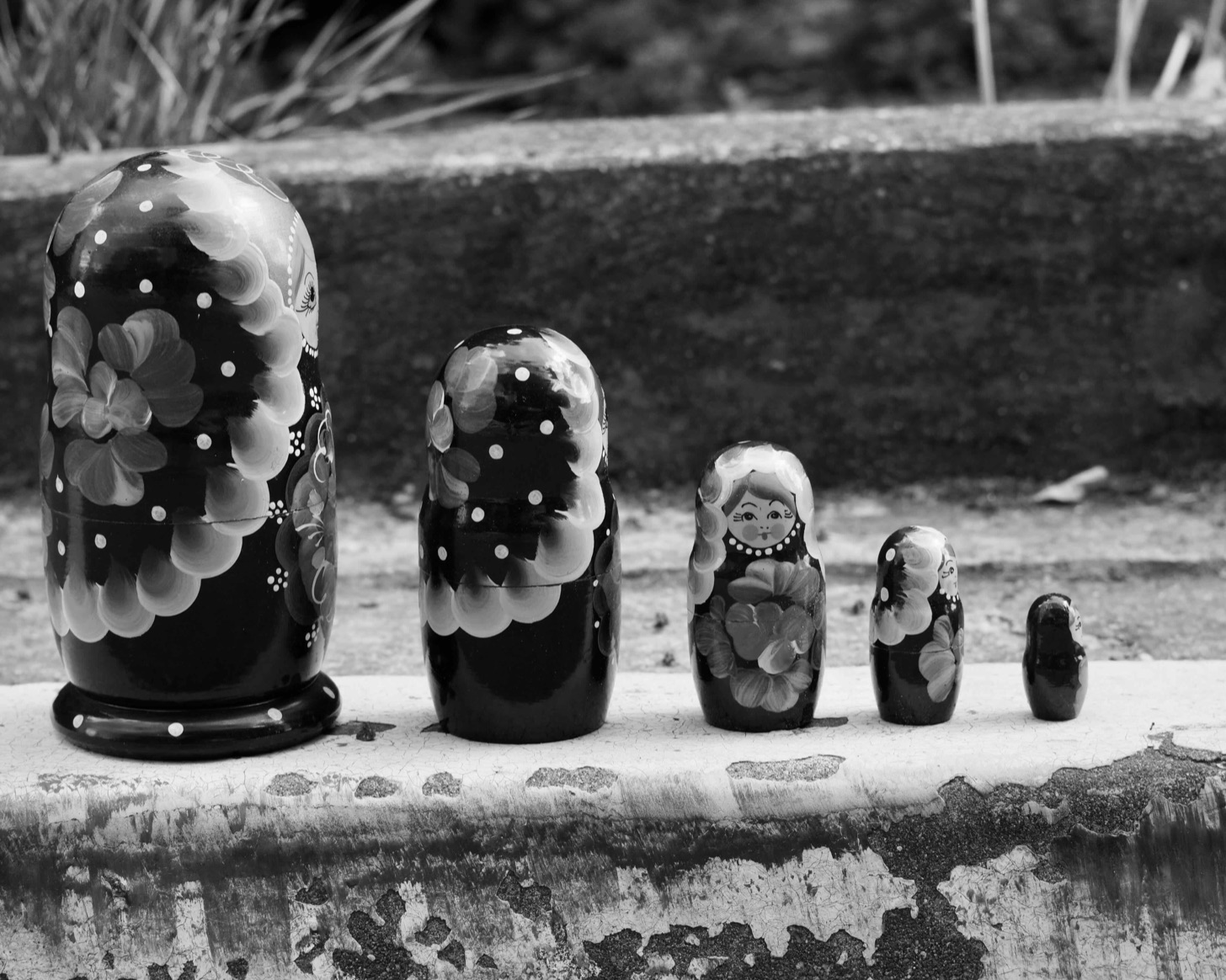 A row of matryoshka nesting dolls lined up on a ledge.